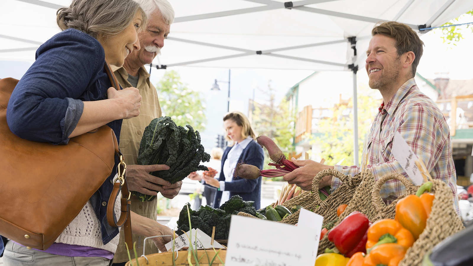 Người đàn ông thanh toán tiền rau ngoài trời bằng thiết bị di động