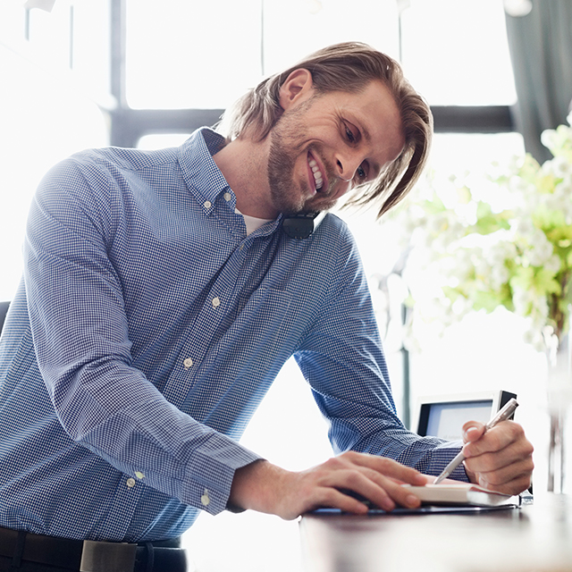 Người chủ trẻ của quán cà phê đang đứng trước cơ sở kinh doanh của mình