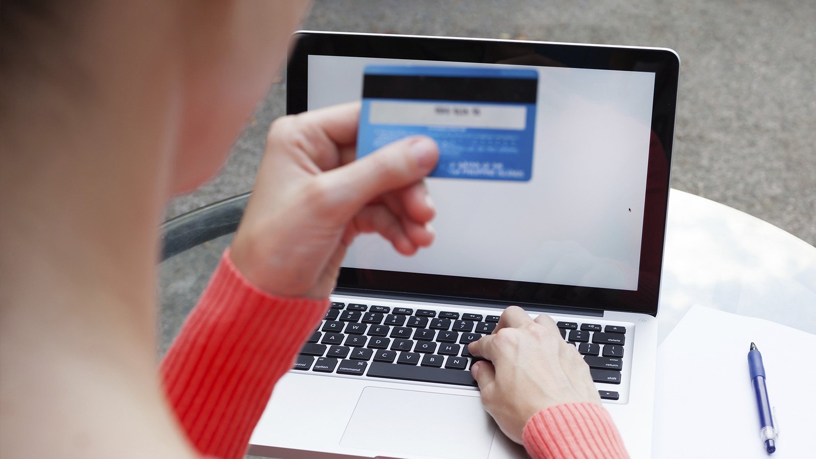 Woman at laptop checking Card Verification Value 2 of Visa card.