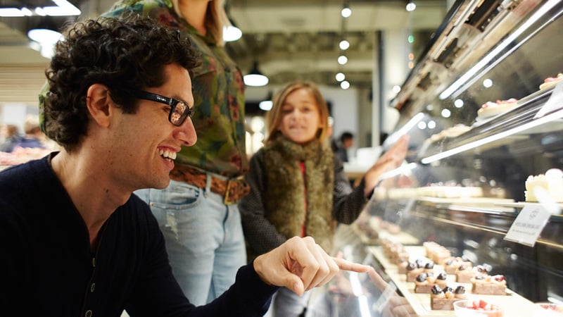 man looking at food counter