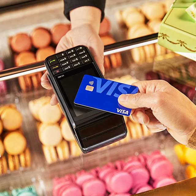 Picture of tap to pay contactless Visa card purchasing macarons