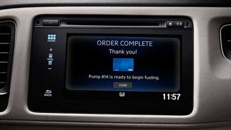 A car console displaying an order complete message above a Visa card with an additional indication that a gas pump is ready to be used.