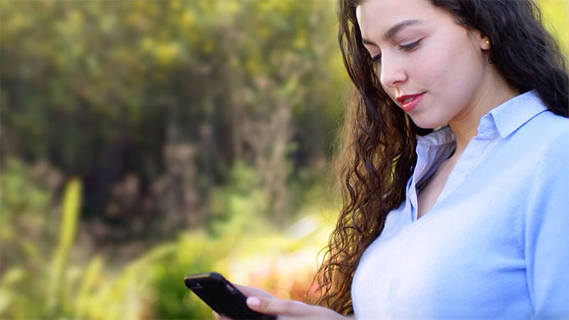 A woman reviews her cell phone screen.