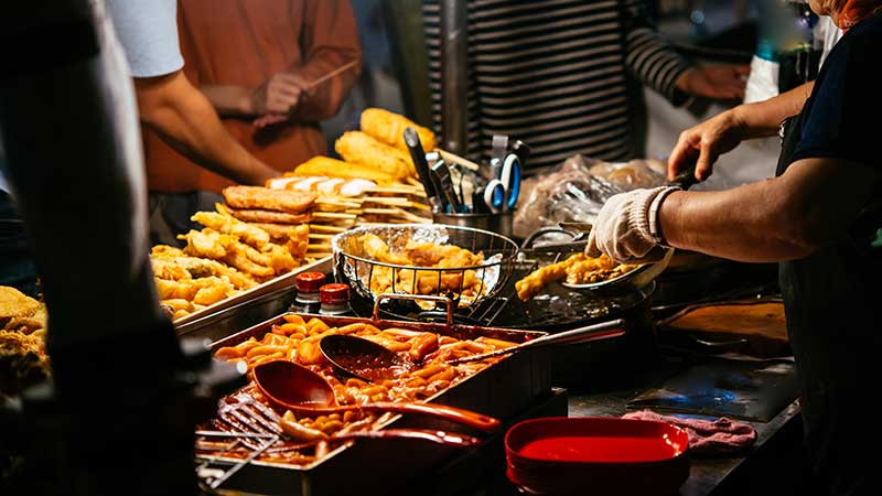 Different street food on sale in the evening streets