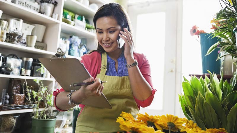 lady looking at list board while on a call