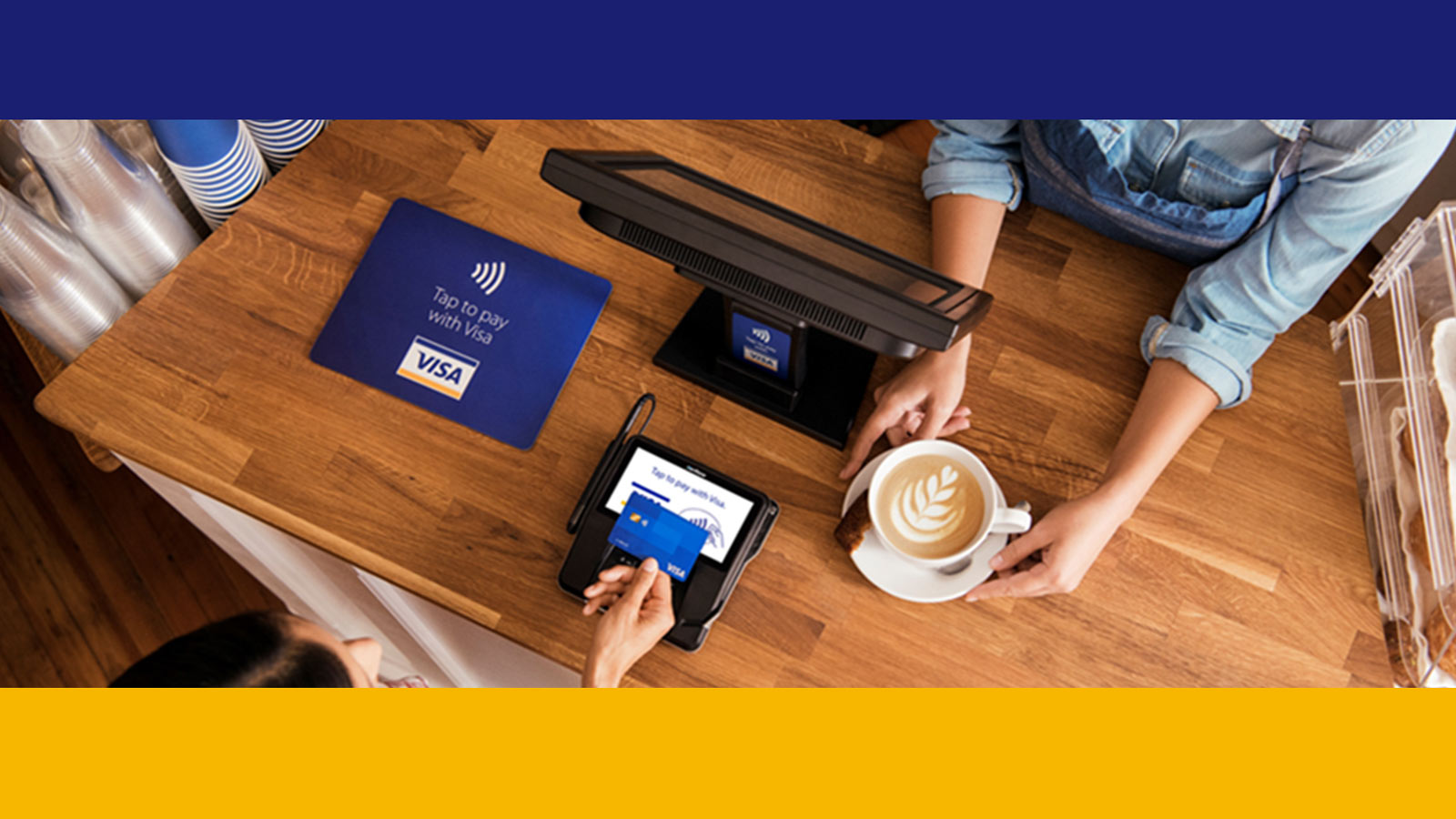 Image of an individual buying a coffee and paying using a Visa card for a cashless payment.